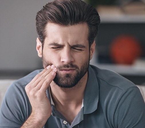 Man in pain holding his cheek