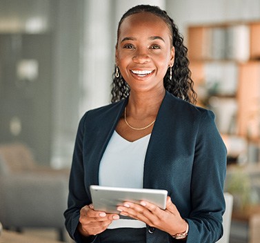 Smiling woman holding tablet in office