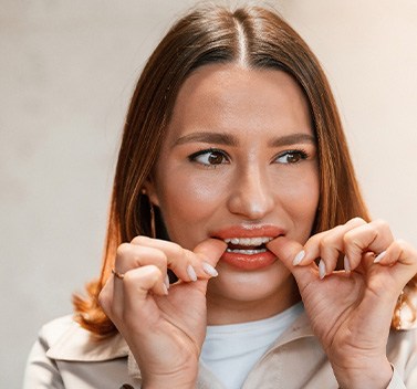 Patient putting on clear aligner in treatment room