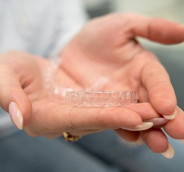 Closeup of patient holding clear aligner