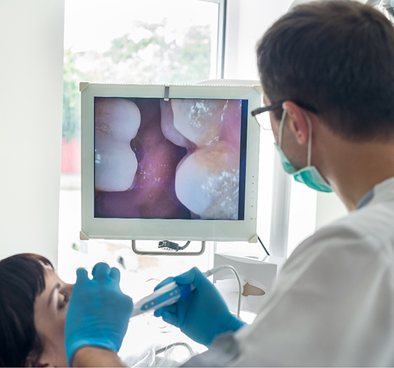 Dentist using intraoral camera to closely examine patient's teeth