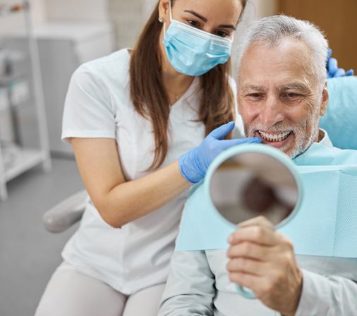 Patient admiring his teeth after a dental cleaning