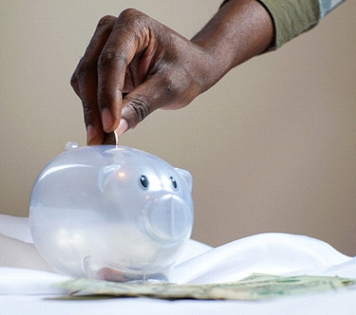 Hand putting coin in piggy bank