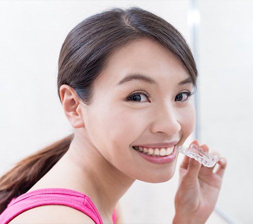 Woman placing Invisalign tray