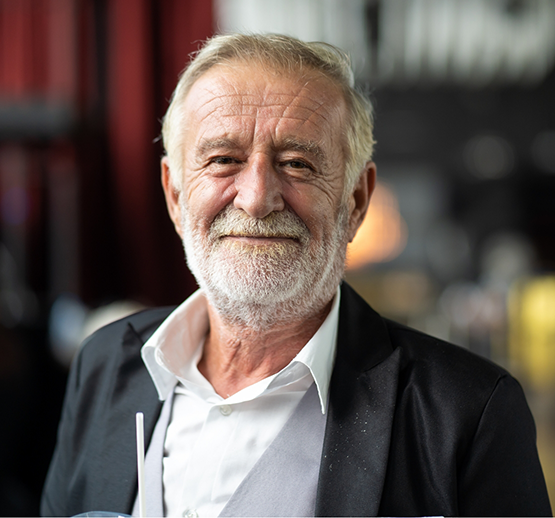 Bearded man in black suit smiling