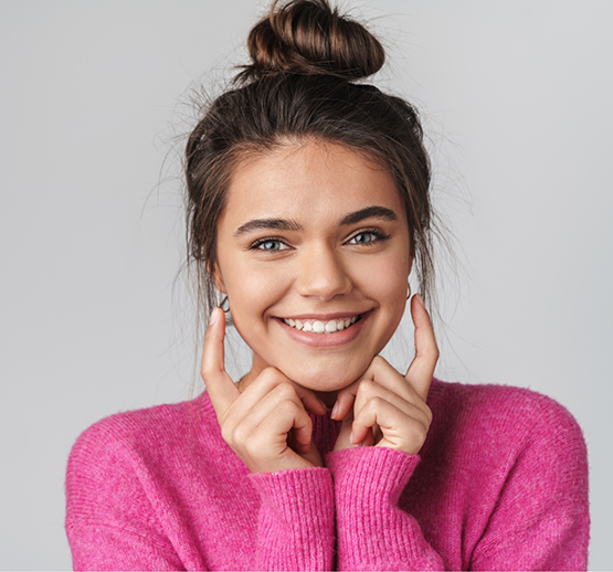 Young woman in pink sweater smiling