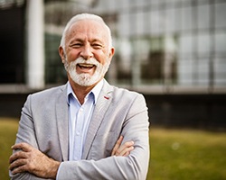 An older businessman laughing while looking into the camera