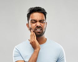 Man with toothache touching his cheek