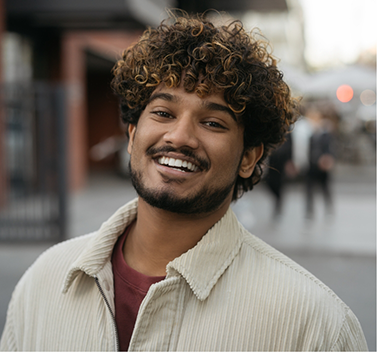 Man in collared beige shirt smiling
