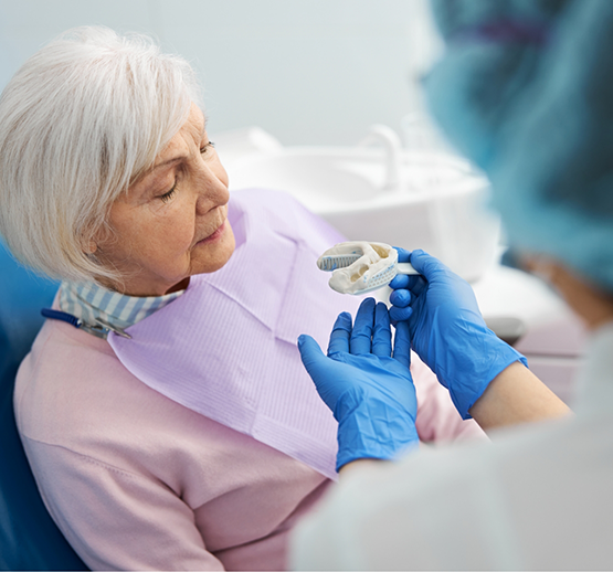 Senior woman looking at dental impression