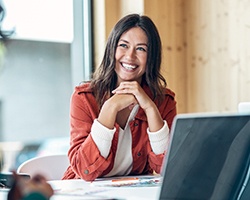 Woman smiling at colleague while working in office