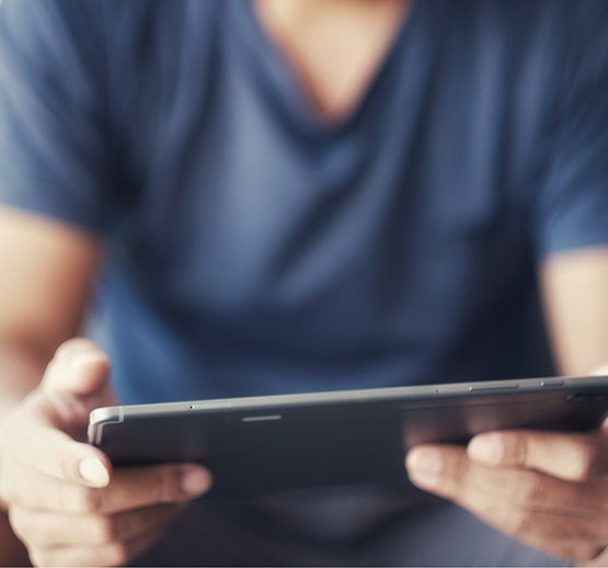 Man in blue shirt holding a tablet