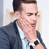 Man in pain holding jaw