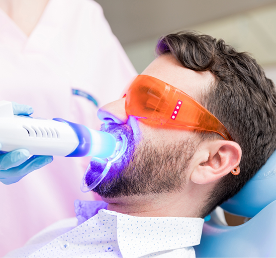Man with protective glasses receiving teeth whitening in Midlothian