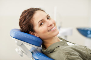 Woman smiling at dentist office after COVID-19 quarantine