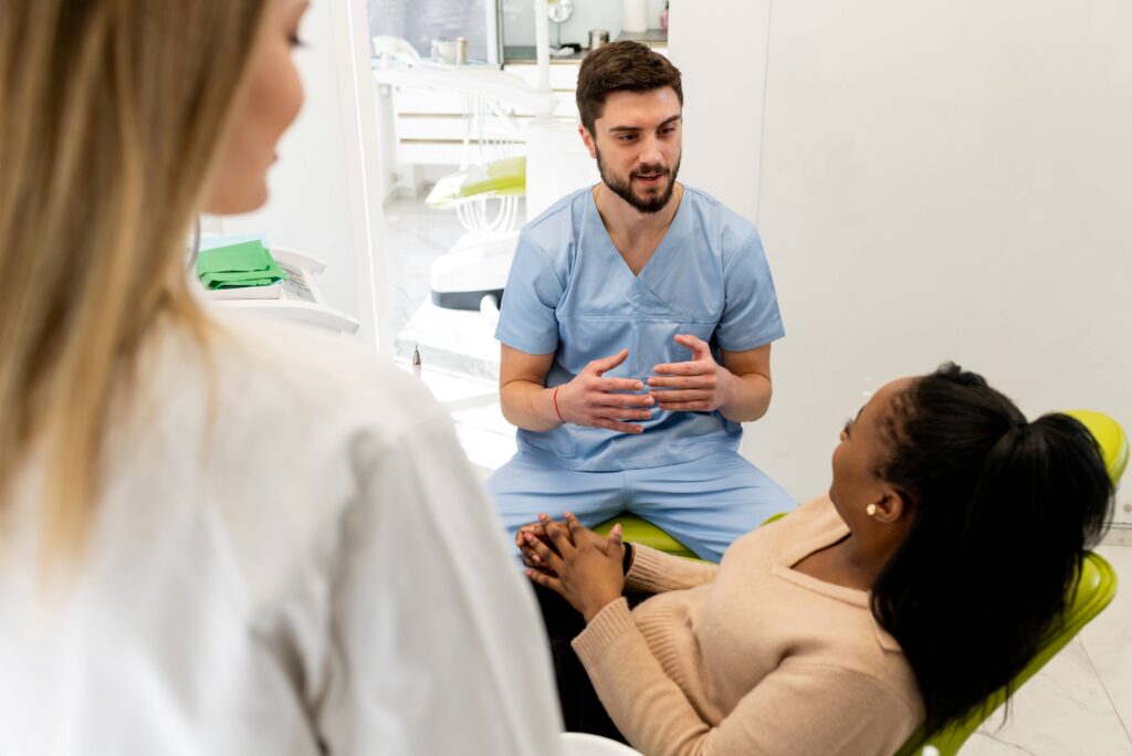 Dentist talking to smiling patient in treatment chair