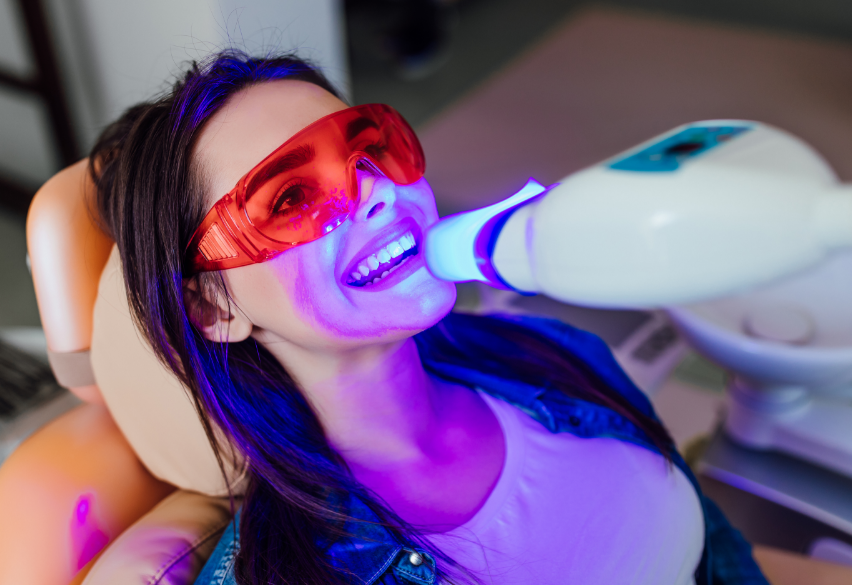 Woman in dental chair undergoing teeth whitening